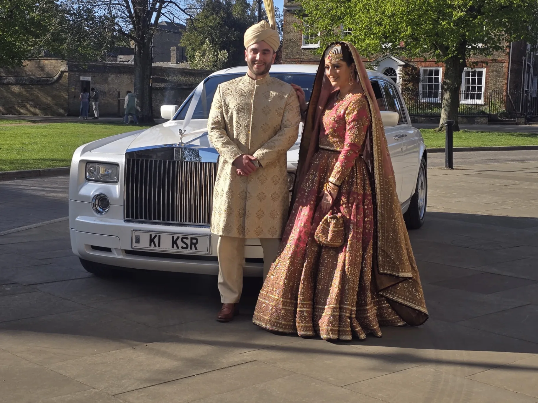 Bride in a red lehenga arriving for an Asian wedding